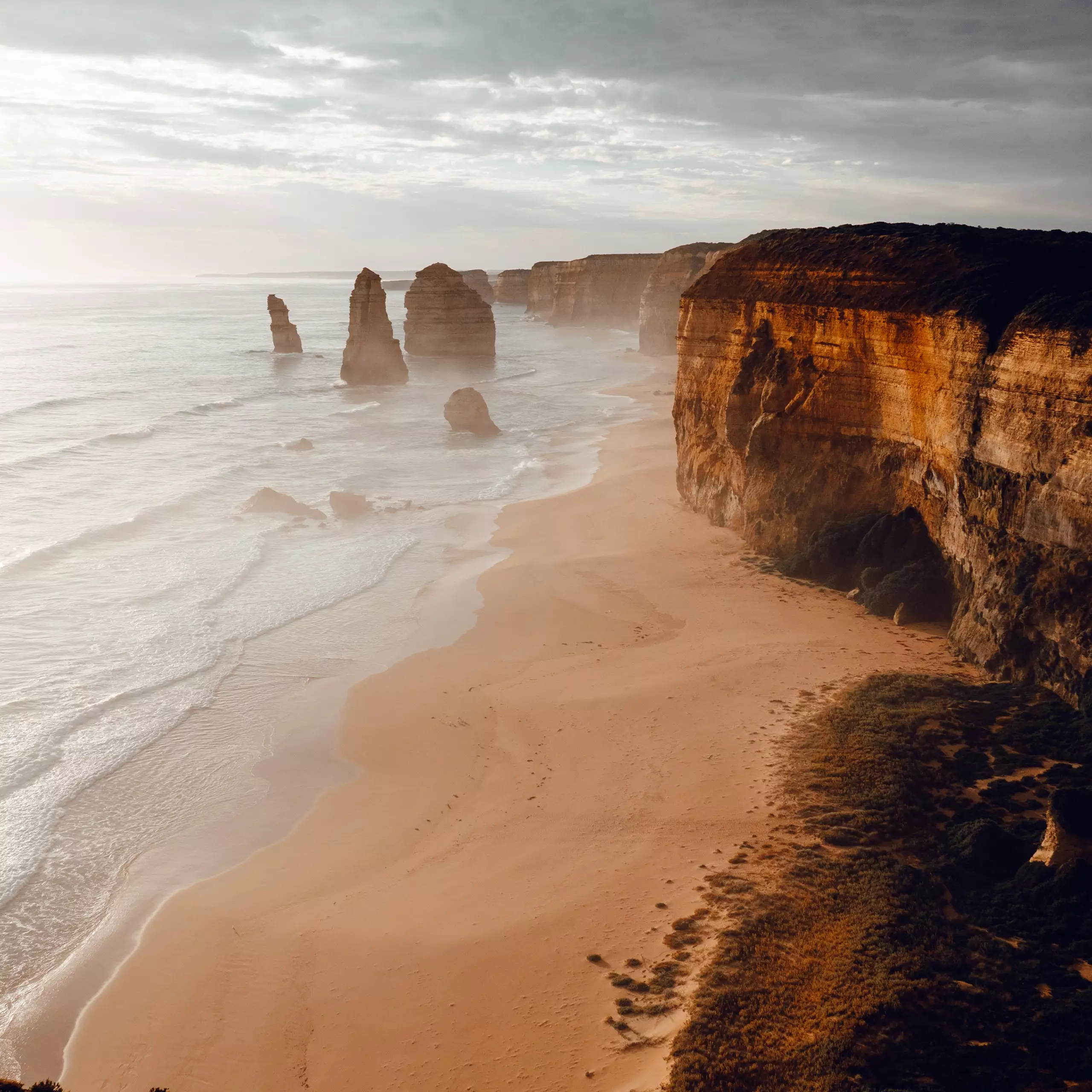 Felsformationen und Klippen an einem nebligen Strand in Australien, geeignet für Reisewerbung und Travel Design.